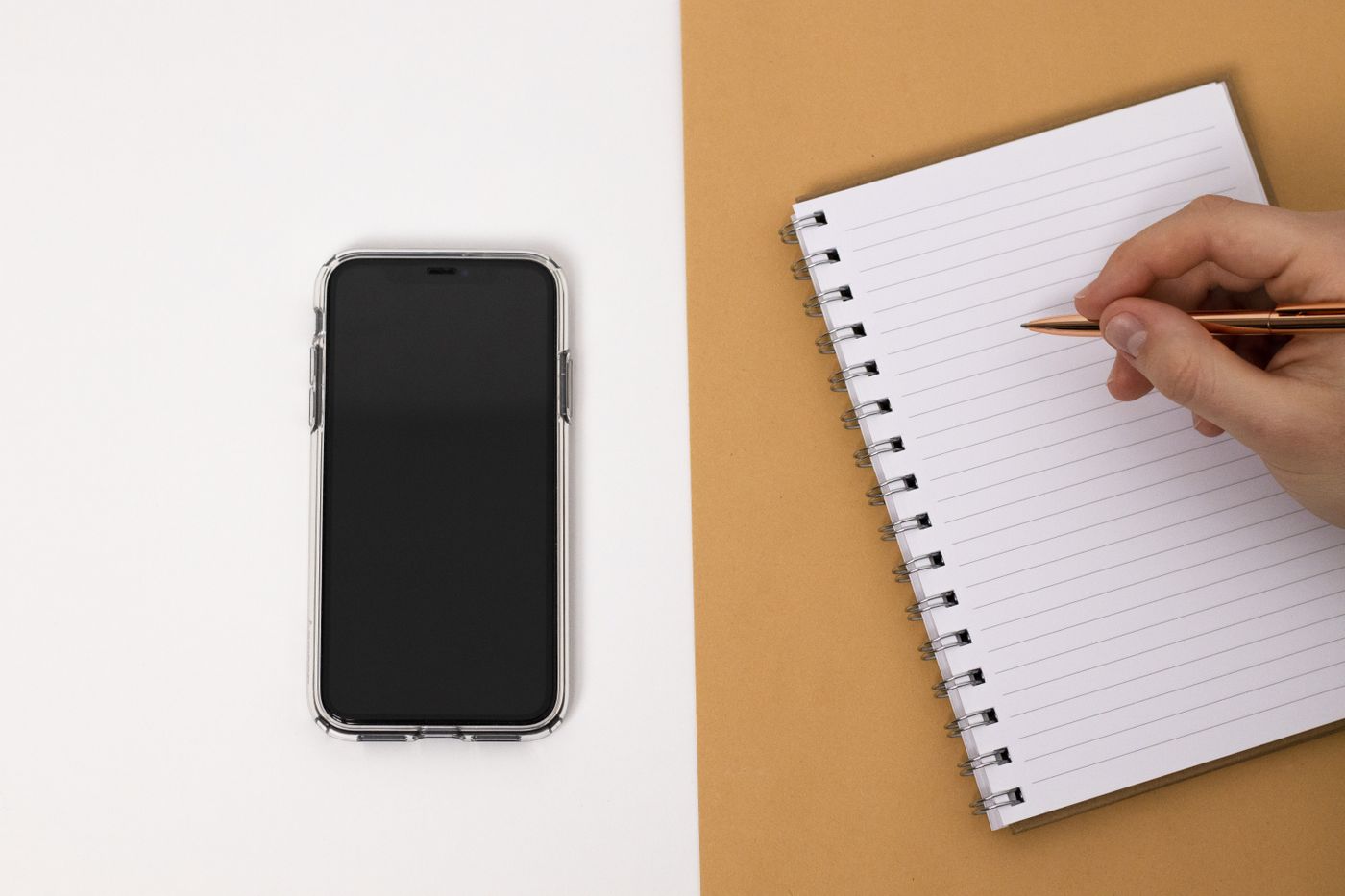 Writing troubleshooting notes beside a smartphone